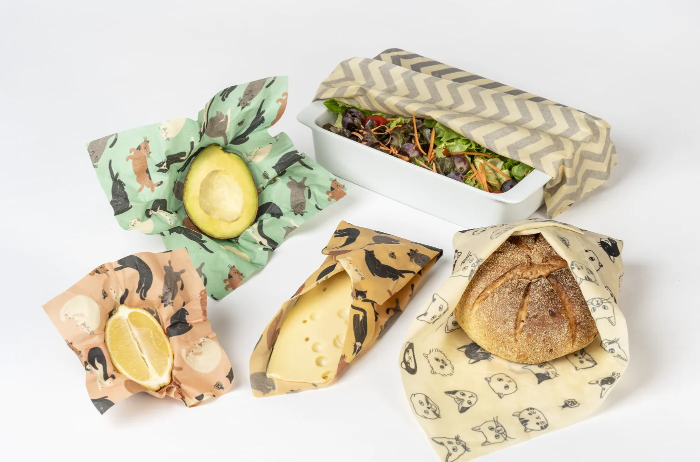 Bienenwachstücher im Einsatz: um Avocado, Zitrone, Käse und Brot gewickelt und über einer Salatschale
